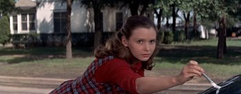 Movie still from “Picnic” (1955), directed by Joshua Logan – A young woman in a plaid shirt and a red plaid dress; Medium shot, Low angle