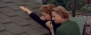 Movie still from “Picnic” (1955), directed by Joshua Logan – Two women leaning on the roof of a house; Close Up shot, Overhead angle