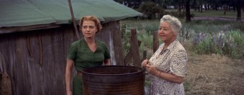 Movie still from “Picnic” (1955), directed by Joshua Logan – Two women standing in front of a large pot; Medium shot, Low angle