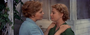 Movie still from “Picnic” (1955), directed by Joshua Logan – Two women standing next to each other in front of a counter; Close Up shot, Over the shoulder angle