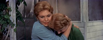 Movie still from “Picnic” (1955), directed by Joshua Logan – An older woman hugging a younger woman in front of a wall; Close Up shot, Over the shoulder angle