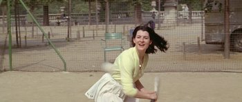 Movie still from “Pierrot le Fou” (1965), directed by Jean-Luc Godard – A young woman holding a baseball bat on a field; Medium shot, High angle