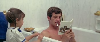 Movie still from “Pierrot le Fou” (1965), directed by Jean-Luc Godard – A man in a bath tub reading a book; Medium shot, High angle