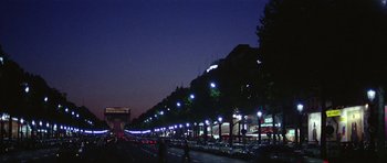 Movie still from “Pierrot le Fou” (1965), directed by Jean-Luc Godard – A city street at night lit up by street lights; Extreme Wide shot, Low angle