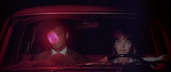Movie still from “Pierrot le Fou” (1965), directed by Jean-Luc Godard – A man and a woman in the back seat of a car; Close Up shot, Over the shoulder angle