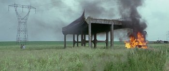 Movie still from “Pierrot le Fou” (1965), directed by Jean-Luc Godard – An old structure in the middle of a grassy field; Extreme Wide shot, Low angle