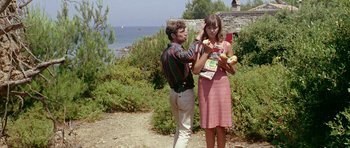Movie still from “Pierrot le Fou” (1965), directed by Jean-Luc Godard – A man and a woman standing next to each other on a beach; Medium shot, Low angle