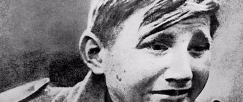 Movie still from “Pierrot le Fou” (1965), directed by Jean-Luc Godard – An old black and white photo of a man's face; Extreme Close Up shot, High angle