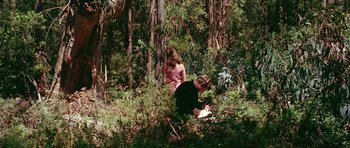 Movie still from “Pierrot le Fou” (1965), directed by Jean-Luc Godard – A man and a woman sitting in the woods; Wide shot, High angle