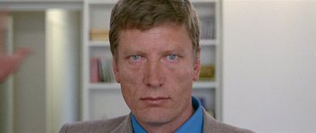 Movie still from “Pierrot le Fou” (1965), directed by Jean-Luc Godard – A person wearing a suit; Close Up shot, Low angle