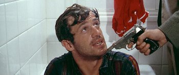 Movie still from “Pierrot le Fou” (1965), directed by Jean-Luc Godard – A man with a knife in his mouth; Close Up shot, Low angle