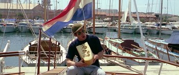 Movie still from “Pierrot le Fou” (1965), directed by Jean-Luc Godard – A man sitting on the deck of a sailboat; Medium shot, Low angle