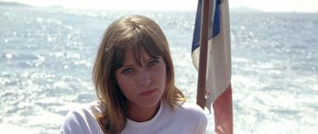 Movie still from “Pierrot le Fou” (1965), directed by Jean-Luc Godard – A beautiful woman sitting on top of a boat; Close Up shot, Low angle