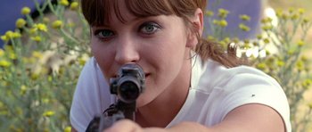 Movie still from “Pierrot le Fou” (1965), directed by Jean-Luc Godard – A woman is holding a gun in her mouth; Close Up shot, Low angle