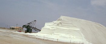 Movie still from “Pierrot le Fou” (1965), directed by Jean-Luc Godard – A large pile of snow next to a large crane; Extreme Wide shot, Low angle