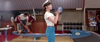 Movie still from “Pierrot le Fou” (1965), directed by Jean-Luc Godard – A woman in a sailor's hat holding a bowling ball; Medium shot, Low angle