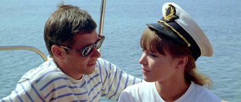 Movie still from “Pierrot le Fou” (1965), directed by Jean-Luc Godard – A man and a woman sitting next to each other on a boat; Close Up shot, High angle