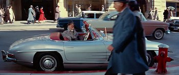 Movie still from “Pillow Talk” (1959), directed by Michael Gordon – An older man driving a car on the street; Wide shot, High angle