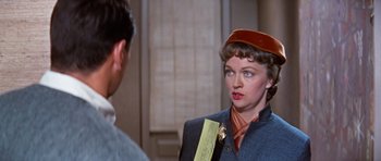 Movie still from “Pillow Talk” (1959), directed by Michael Gordon – A woman wearing a red hat and holding a piece of paper; Close Up shot, Over the shoulder angle