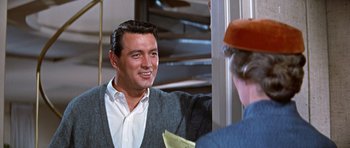 Movie still from “Pillow Talk” (1959), directed by Michael Gordon – A man smiling while looking into a mirror; Medium shot, Over the shoulder angle