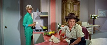 Movie still from “Pillow Talk” (1959), directed by Michael Gordon – A woman sitting at a table holding a phone; Medium shot, High angle