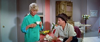 Movie still from “Pillow Talk” (1959), directed by Michael Gordon – Two women sitting at a table with a cup of tea; Medium shot, High angle