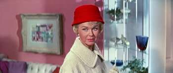 Movie still from “Pillow Talk” (1959), directed by Michael Gordon – An older woman wearing a white coat and a red hat; Close Up shot, Low angle