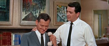 Movie still from “Pillow Talk” (1959), directed by Michael Gordon – Two men in suits and ties are talking to each other; Medium shot, Low angle