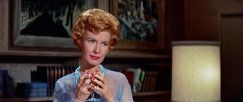 Movie still from “Pillow Talk” (1959), directed by Michael Gordon – A woman in a blue dress holding a glass of wine; Close Up shot, Low angle