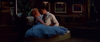 Movie still from “Pillow Talk” (1959), directed by Michael Gordon – A man and a woman sitting on top of a couch; Wide shot, Low angle