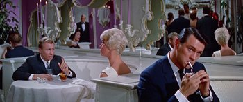 Movie still from “Pillow Talk” (1959), directed by Michael Gordon – A man and a woman sitting at a table in front of a mirror; Medium shot, Low angle