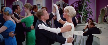 Movie still from “Pillow Talk” (1959), directed by Michael Gordon – A man and a woman dancing in white gloves; Medium shot, Low angle
