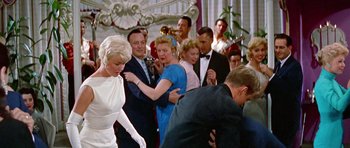 Movie still from “Pillow Talk” (1959), directed by Michael Gordon – A group of people standing in a room; Wide shot, Low angle