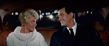 Movie still from “Pillow Talk” (1959), directed by Michael Gordon – A man and a woman sitting next to each other in a car; Close Up shot, Low angle