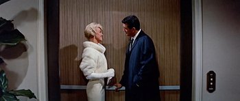 Movie still from “Pillow Talk” (1959), directed by Michael Gordon – A man and a woman standing next to each other in front of a wall; Medium shot, Low angle