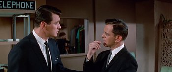 Movie still from “Pillow Talk” (1959), directed by Michael Gordon – Two men in suits and ties in front of a mirror; Medium shot, Over the shoulder angle
