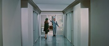Movie still from “Pillow Talk” (1959), directed by Michael Gordon – A man and a woman walking down a hall way; Wide shot, High angle