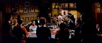 Movie still from “Pillow Talk” (1959), directed by Michael Gordon – A group of people sitting at a table in a restaurant; Wide shot, High angle