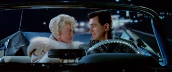 Movie still from “Pillow Talk” (1959), directed by Michael Gordon – A man and a woman sitting in the back of a car; Medium shot, Low angle