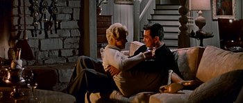 Movie still from “Pillow Talk” (1959), directed by Michael Gordon – An older couple sitting on a couch drinking wine; Wide shot, High angle