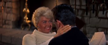 Movie still from “Pillow Talk” (1959), directed by Michael Gordon – An older woman and a younger man are smiling at each other; Close Up shot, High angle