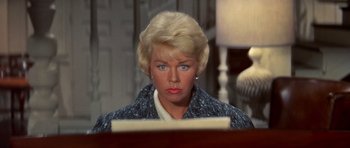 Movie still from “Pillow Talk” (1959), directed by Michael Gordon – A woman with blonde hair sitting in front of a computer keyboard; Close Up shot, High angle