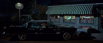 Movie still from “Pillow Talk” (1959), directed by Michael Gordon – A couple is sitting in the back seat of a black car; Wide shot, Over the shoulder angle