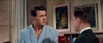 Movie still from “Pillow Talk” (1959), directed by Michael Gordon – A man holding a glass of orange juice in his hand; Medium shot, Over the shoulder angle