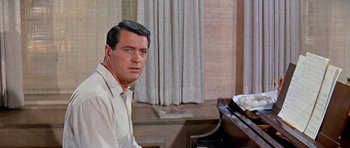 Movie still from “Pillow Talk” (1959), directed by Michael Gordon – A person sitting at a piano near a window; Close Up shot, High angle