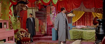 Movie still from “Pillow Talk” (1959), directed by Michael Gordon – A man in a long coat and a tie in a room; Wide shot, High angle