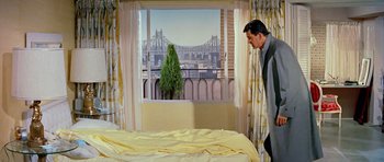 Movie still from “Pillow Talk” (1959), directed by Michael Gordon – A man standing in front of a bed looking out of a window; Wide shot, High angle