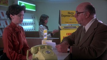 Movie still from “Piranha” (1978), directed by Joe Dante – A man sitting at a table in front of a woman; Medium shot, Over the shoulder angle