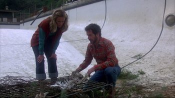 Movie still from “Piranha” (1978), directed by Joe Dante – A man and a woman looking at dead animals; Medium shot, High angle