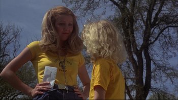 Movie still from “Piranha” (1978), directed by Joe Dante – A woman and a child in yellow shirts talking to each other; Medium shot, Low angle